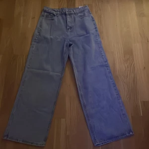 Blå jeans med hög midja - Säljer ett par snygga blå jeans i mycket bra skick. De har en hög midja och en loose passform som ger en avslappnad stil. Perfekta för både vardag och fest! 🕺