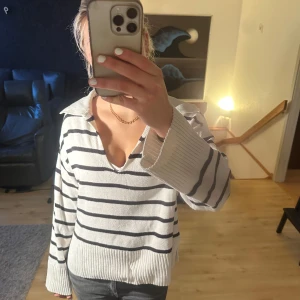 Vit och svart randig tröja - Säljer en snygg vit tröja med svarta ränder ifrån Gina. Den har en v-ringad design och långa ärmar, perfekt för en avslappnad stil. Tröjan är i bra skick och passar perfekt till både jeans och kjol. Perfekt för vår och höst! 🍂  (OBS har en mini fläck på magen som man knappt ser, skriv för bild!) 