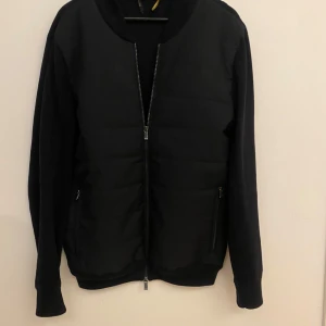 Massimo dutti cardigan - Säljer en stilren Massimo dutti cardigan i mycket bra skick. Jackan har en dragkedja framtill. Perfekt för höst och vår, och den passar till nästan alla outfits. Den är gjord av ett syntetmaterial som känns både lätt och bekvämt. Perfekt för dig som vill ha en klassisk look!