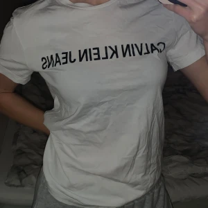 Vit t-shirt från Calvin Klein Jeans - Säljer en vit t-shirt från Calvin Klein Jeans. Den har en normal passform och korta ärmar. T-shirten är i bomull och har märkets logga tryckt i svart på framsidan.