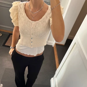 Beige stickad kofta  - Beige stickad kofta/bolero med volanger från dilvin. Kan inte hitta storlek men skulle säga S/M. Fint skick. Använd gärna köp nu!