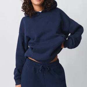 Mörkblå hoodie - Säljer en stilren mörkblå hoodie med en bekväm passform. Den har en klassisk huva och en stor ficka framtill. Perfekt för en avslappnad look. Använd fåtal gånger 