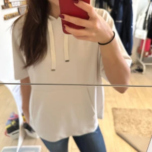 Vit hoodie från Soyaconcept - Säljer en supermjuk och bekväm vit hoodie från Soyaconcept. Perfekt för en avslappnad stil med sin lösa passform och korta ärmar. Den har en klassisk huva med snören. Passar perfekt till jeans för en casual look. 🕶️DEN ÄR HELT SLUTSÅLD! 