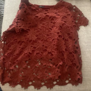 Rostfärgad spetsblus från Stockh lm - Säljer en jätte fin vinröd spetsblus från Stockh lm😍😍Blusen har ett detaljerat spetsmönster och korta ärmar. Perfekt för att ge en elegant touch till din outfit💕💕