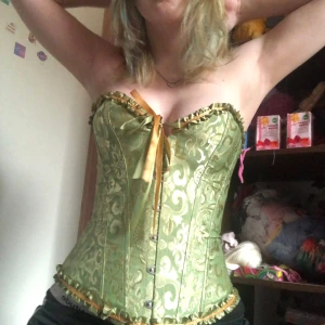 Söt grön korsett 🫶🏻 - Väldigt fin knappt använd bra kvalitet korsett,Den formar bra mot kroppen och är skönt material, man kan justera där bak hur tight den ska sitta. Säljer då den inte är min stil längre tyvärr. Passar jättefint till nästan allt😽