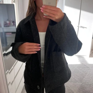 Svart kappa med knappar och fickor - Säljer en super fin svart kappa med knappar, stora fickor och slejf med knapp i ärmslut från lager 157 i storlek S. Perfekt för höst, vinter eller vår. Använd bara några frå gånger då jag tycker att den är lite för stor för mig!