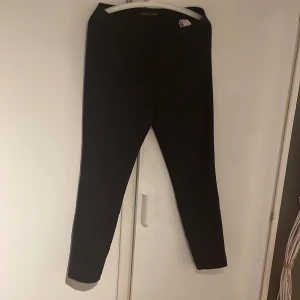 Svarta byxor - Säljer ett par svarta byxor i bra skick. De är enkla och stilrena, perfekta för både vardag och fest. Byxorna har en tight passform och är högmidjade, vilket ger en snygg siluett.