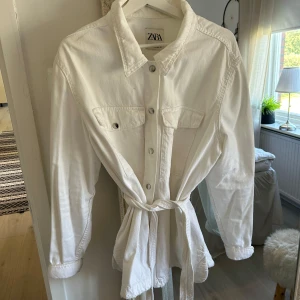 Jeansjacka - Då denna favorit inte kommer till användning längre säljer jag den vidare, fin fräsch Skjortjacka med bröstfickor och knappar samt bälte och lite fransig längst ner & på bältet.Finns nån fläck bak som säkert går bort i tvätt annars är den som ny!