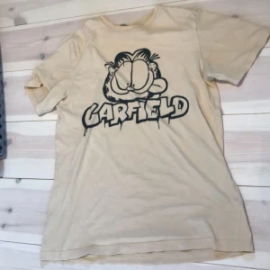 beige garfield t-shirt - super fin garfield t-shirt i storlek 158/164, ungefär S. Bra skick, använd 2-3 ggr. (inte mina bilder)