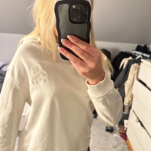 Vit hoodie från Alix The Label - Säljer en stilren vit hoodie från Alix The Label. Tröjan har en luva och text på ryggen. Säljer då den är för liten för mig🥰