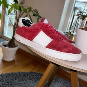 Valentino Flycrew - Valentino Flycrews med nitar runt sulan. Alla nitarna finns kvar kvar dock har en lossnat men ja skickar med den.  Skorna har en kombination av mocka och skinnmaterial, vilket ger en stilren look. Perfekta för att ge din outfit en extra edge.