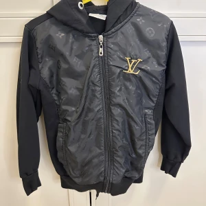 Barn tracksuit strl 122/128 - Hoodie med byxa. Använd fåtal gånger. I väldigt fint skick!  Stroken 122/128. Kan även användas som övergångs jacka. 