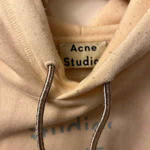 Beige hoodie från Acne Studios - Tja! Säljer en tjock hoodie från Acne Studios. Hoodien har ett tryck på ryggen och är mer åt det oversized hållet. Hoodien är hyfsat stor och skulle passat någon runt 185. Pris kan diskuteras!