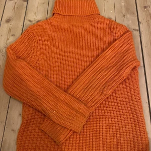 Orange stickad polotröja - Säljer en härlig orange stickad polotröja med långa ärmar. Perfekt för kyliga dagar och ger en färgklick till din outfit. Tröjan har en mysig och varm känsla. Använd några få ggr:)