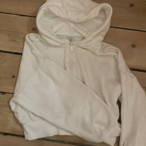 Vit hoodie från Lindex st. 134-140 - Säljer en vit hoodie från Lindex i storlek 134/140 för barn. Den har en dragkedja framtill och en mysig huva. Perfekt för kyliga dagar. 🧥