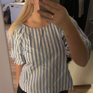 Blå- och vitrandig blus - Säljer en söt blus med blå och vita ränder & puffärmar. perfekt inför sommaren!