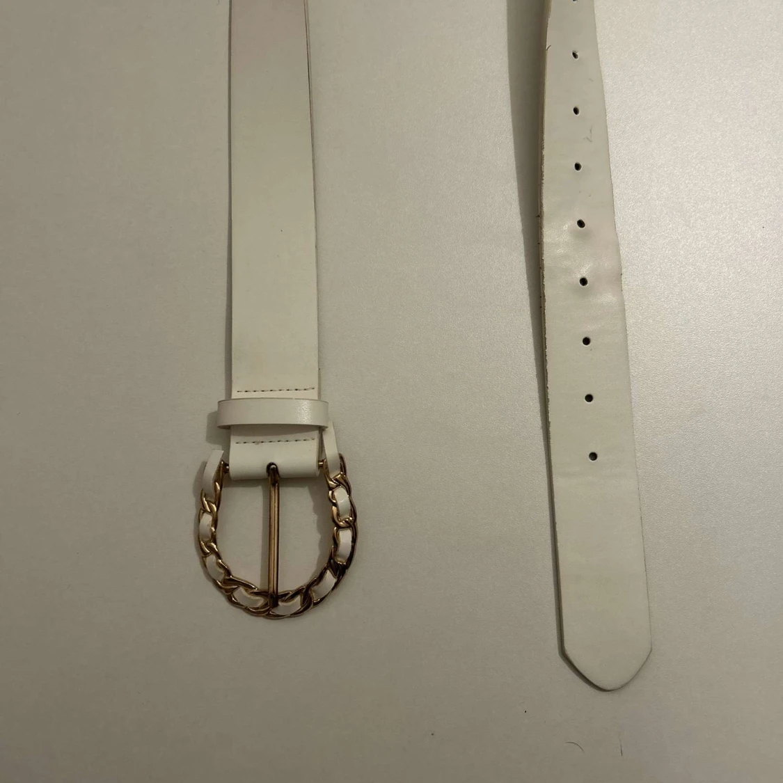 Vitt bälte med gulddetaljer