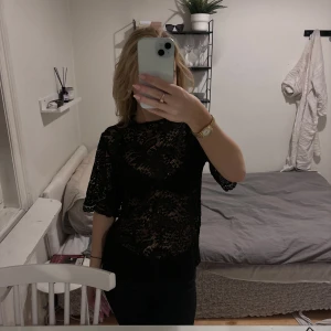 Svart spetsblus - Elegant svart spetsblus med korta ärmar och ett vackert mönster. Perfekt för en stilfull look. Spetstoppen har en loosefit och passar bra till mycket. 🩷