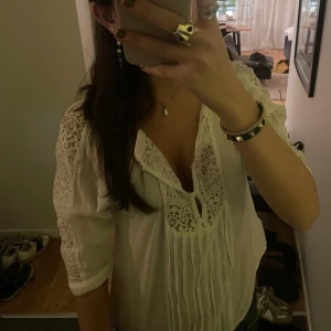 Vit blus med spetsdetaljer - Säljer en söt vit blus med spetsdetaljer på axlarna och runt halsen från hollister. Blusen har trekvartsärmar och knappar fram🤍