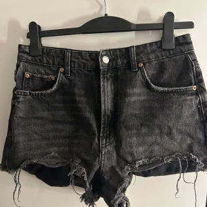Svarta jeansshorts från Zara - Snygga svarta jeansshorts från Zara. Shortsen är högmodjade men man kan ha dem lågmidjade ifall man vill, dem är i storlek 40 men skulle säga dem är en 38 