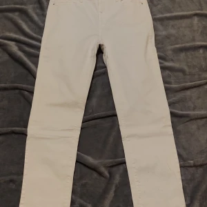 Vita jeansbyxor från Flash jeans - Snygga vita jeansbyxor från Flash jeans med klassisk femficksdesign. Byxorna har en rak passform och är tillverkade i ett slitstarkt material. Röda fläckar på högra änden av byxan, men kan blekas självklart.