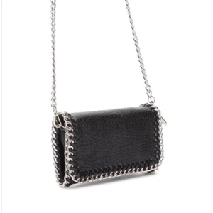 Svart axelväska från tiamo  - Snygg svart axelväska i skinn med coola kedjedetaljer runt kanterna. Väskan har en stilren design och en kedja som axelrem🩷