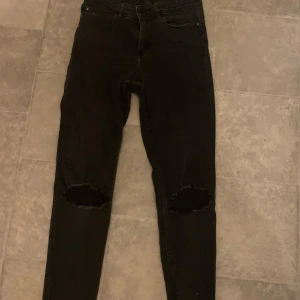 Svarta jeans med slitningar - Snygga svarta jeans med slitningar vid knäna. Lapp saknas men är som S i storlek, stretchigt material 