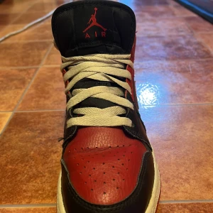 Nike Air Jordans 1 i rött och svart storlek 37,5 - Snygga Nike Air Jordans i klassisk röd och svart färgkombination. Skorna har en hög modell med snörning och den ikoniska Air Jordan-loggan på plösen. Perfekta för sneakerheads som vill ha en tidlös stil. Äkta köpte de för 2000. Storlek 37,5. Har tappat bort lådan.