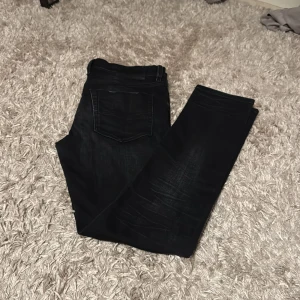 Svarta jeans från Diesel - Snygga svarta jeans från Diesel med knappgylf och klassisk femficksdesign. Perfekta för en stilren look. Jeansen är regular och i väldigt bra skick. Pris kan diskuteras 