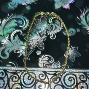 Guldfärgat halsband med tvinnad design - Elegant guldfärgat halsband med en tvinnad design som ger en lyxig känsla. Perfekt för att lyfta vilken outfit som helst. Halsbandet har en säker låsning och en glansig finish. Och passar till allt 