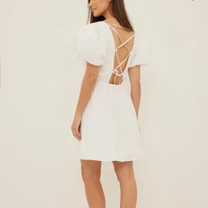 Vit klänning med puffärmar - Säljer en söt vit klänning med puffiga kortärmar och öppen rygg med snörning. Perfekt som student klänning🤩 storlek 36 och klänningen är använd max 1 gång. Fler bilder finns om önskat☺️