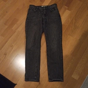 Svarta jeans från Woodbird - Snygga svarta jeans från Woodbird med klassisk femficksdesign. De har en dragkedja och knapp framtill. Perfekta för en stilren look. Nypris 1000kr, inte använda supermycket så väldigt fint skick, skriv gärna om annat pris😁. Storlek 28,32