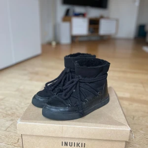 Svarta boots från Inuikii - Snygga svarta boots från Inuikii med snörning och vadderad insida. Perfekta för kyliga dagar och extremt snygga. Sparsamt använda💛 lådan ingår ej