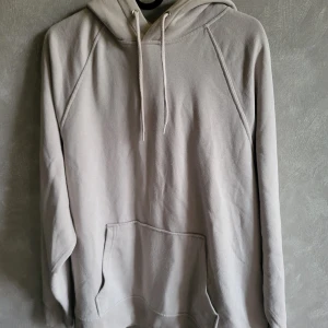 Beige hoodie från H&M Divided - Säljer en stilren beige hoodie från H&M Divided. Den har en klassisk design med känguruficka och justerbar huva med dragsko. Perfekt för en avslappnad look.