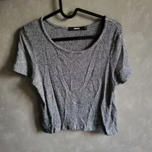 Snygg grå ribbad topp från Bik Bok i storlek S. Toppen har korta ärmar och en rund halsringning, perfekt för en avslappnad stil.