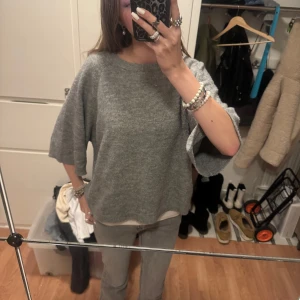 Grå tröja från 157 - Säljer en stilren grå tröja från 157 i storlek M. Tröjan har en lös passform med trekvartsärmar och är tillverkad i ett mjukt material. Perfekt för en avslappnad look.