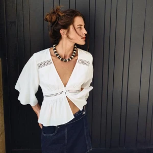 Vit blus med volangdetaljer - Snygg vit blus med volangdetaljer och v-ringning. Blusen har trekvartsärmar och dekorativa spetsinslag. Perfekt för en stilren look. Säljer då den är för liten. Pris kan diskuteras, och kontakta gärna vid frågor!💗