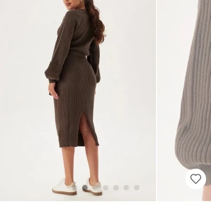 Brun ribbad klänning med knytband - Snygg brun ribbad klänning med långa ärmar och ett knytband i midjan. Klänningen har en slits baktill och är perfekt för en stilren look.
