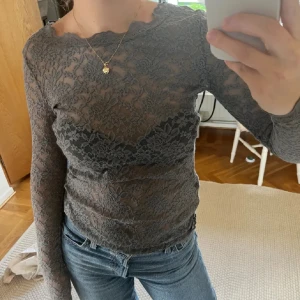 Grå spetsblus från rosemunde - Snygg grå spetsblus från rosemunde med långärmad modell. Blusen har ett  blommönster och en fin kantdetalj vid halsen.❤️ köpt på Sellpy för ett år sen❤️ jätte fint skick