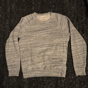 Our Legacy blue grey melange sweater AW14 - Säljer en stilren gråmelerad tröja från Our Legacy.  Nypris är cirka 1500kr. Inga problem med tröjan och har inget direkt slitage eller något från vad jag vet. Passar som M