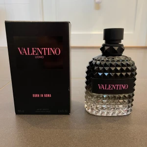 Valentino Uomo Born in Roma Eau de Toilette - Säljer en flaska Valentino Uomo Born in Roma Eau de Toilette. Flaskan har en elegant design med svart, nitat mönster och rymmer 100 ml. Doften är modern och maskulin, perfekt för den stilmedvetna.