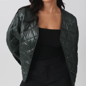 Grön quiltad jacka  - Snygg grön quiltad jacka med knappar. Perfekt för lager-på-lager och ger en stilren look. Jackan har en normal passform och är långärmad. Har aldrig använt den. Tänkte matcha den till gröan sneakers med blev aldrig att jag köpte de så därav har den inte kommit till användning. Den är slut på hemsidan💓Pris kan alltid diskuteras😁