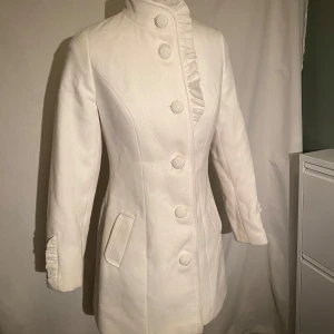 Vit yllekappa - Köpt på second hand och använd men passar mig inte längre! Fickorna är uppsprättade så de går ner i fodret, men de var inte mycket att tala om ändå. Helt underbar passform, får en att känna sig som en isprinsessa (: ca storlek S