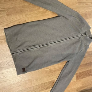Grå/brun zip från Lindbergh - Ribbad grå fullzip från Lindbergh, pris kan diskuteras.