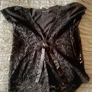 Svart spetsblus med knytband - Söt svart blus med snygga hål  och knytband framtill. 🩵 strl s/m (1)