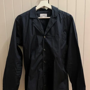 Mörkblå överskjorta  - Elegant mörkblå överskjorta från Eton med  klassisk resort krage och bröstficka framtill. Sitter  true to size