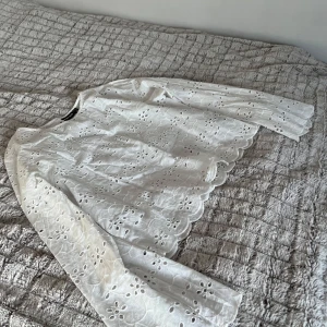 Jättefin vit blus från vero Moda!💕 - Säljer en söt vit blus från Vero Moda i storlek XS. Blusen har ett vackert broderat mönster och långa ärmar med volangdetaljer vid ärmslut och nederkant. Perfekt för en stilren look till sommaren!💕☀️Säljer pga att den inte kommer till användning längre och inte helt passande i storleken, så i mycket bra skick utan defekter!💕
