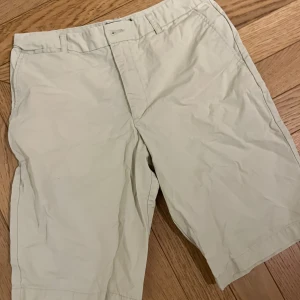 Beige shorts från Ralph Lauren - Snygga beige shorts från Ralph Lauren med klassisk design. Perfekta för en avslappnad stil. De har en knapp och dragkedja framtill samt hällor för bälte.