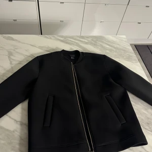 Scuba Jacka (H&M) - Snygg svart jacka med dragkedja framtill och två fickor. Knappt använd. I absolut nyskick. 