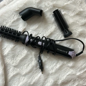 Remington varmluftsborste med tillbehör - Säljer en Remington varmluftsborste med två utbytbara tillbehör. Perfekt för att styla håret med volym och lockar. Borsten är svart med lila detaljer och har en sladd för enkel användning. Nypris 550kr!